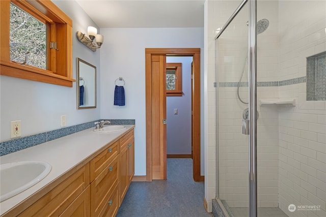 bathroom featuring an enclosed shower and dual bowl vanity