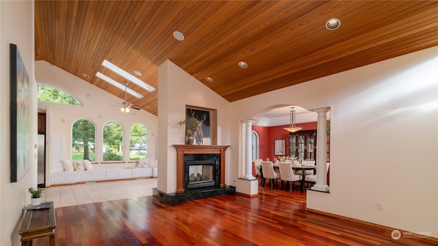 unfurnished living room with ceiling fan, high vaulted ceiling, tile flooring, wood ceiling, and ornate columns