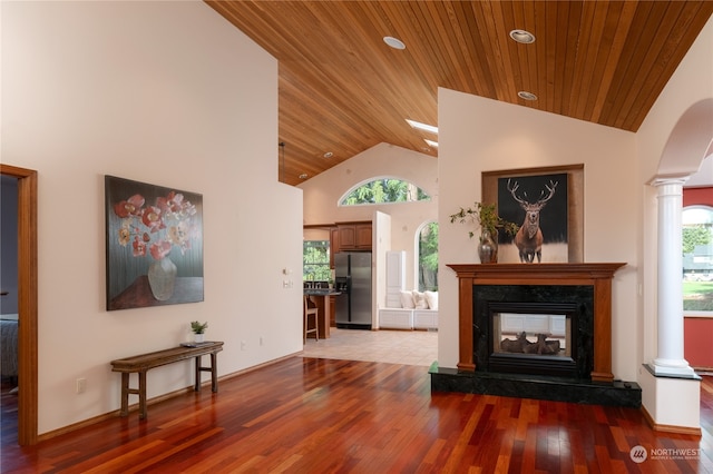 living room with dark hardwood / wood-style flooring, wood ceiling, and ornate columns