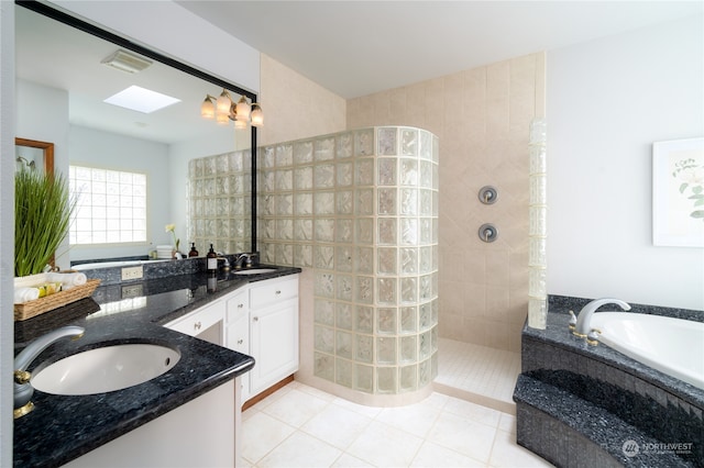 bathroom featuring a skylight, tile floors, dual vanity, and plus walk in shower