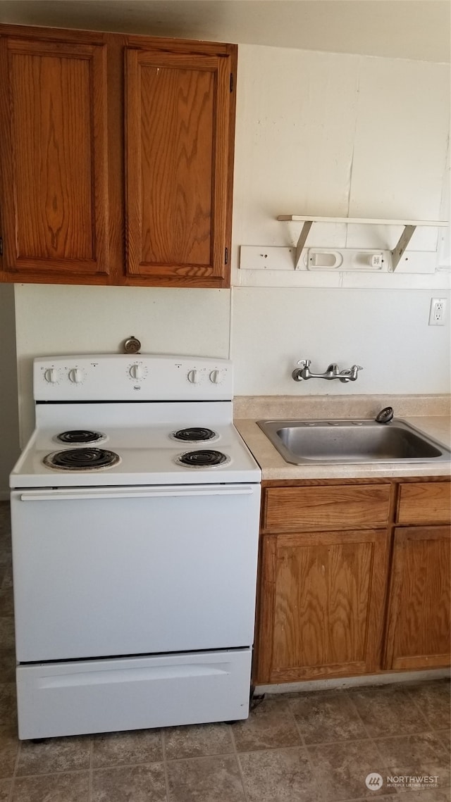 kitchen featuring white electric range oven, sink, and dark tile floors