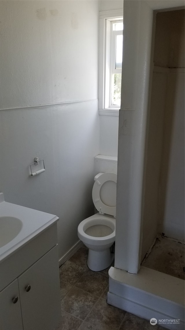 bathroom featuring vanity, toilet, and tile floors