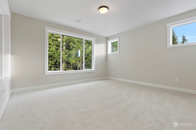 empty room featuring carpet floors and baseboards