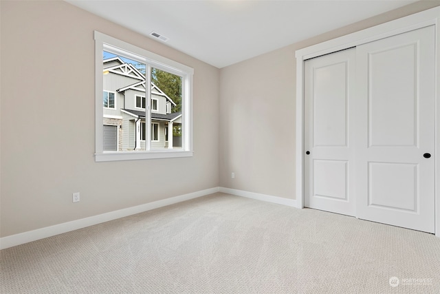 unfurnished bedroom with a closet, baseboards, visible vents, and carpet flooring