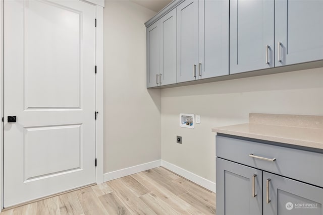 laundry room featuring washer hookup, cabinet space, light wood-style flooring, electric dryer hookup, and baseboards