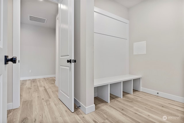 mudroom featuring light wood-style flooring, visible vents, and baseboards