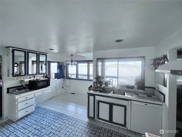 kitchen featuring a chandelier, white dishwasher, light tile flooring, tile counters, and sink