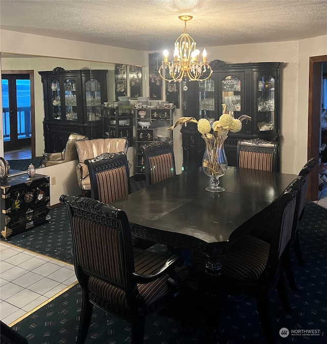 dining room with a notable chandelier, tile floors, and a textured ceiling