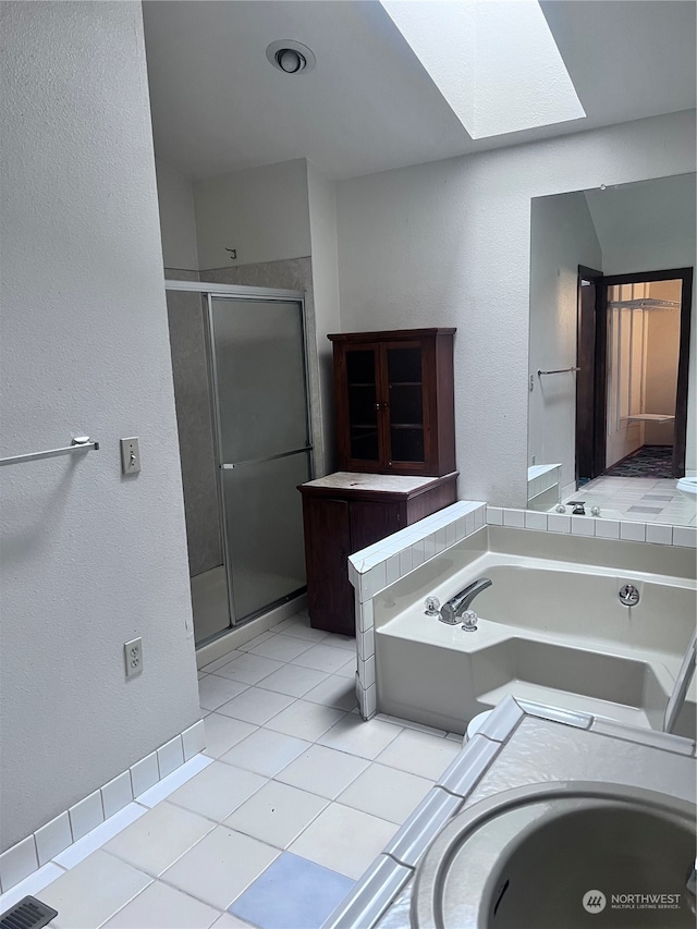 bathroom featuring a skylight, separate shower and tub, and tile floors