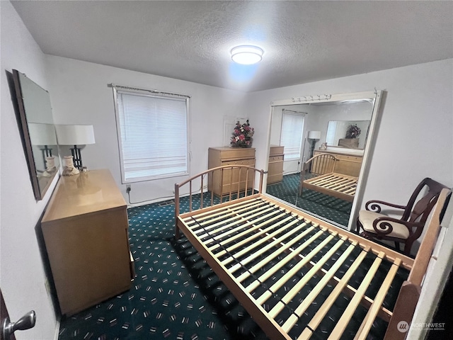 carpeted bedroom featuring a textured ceiling