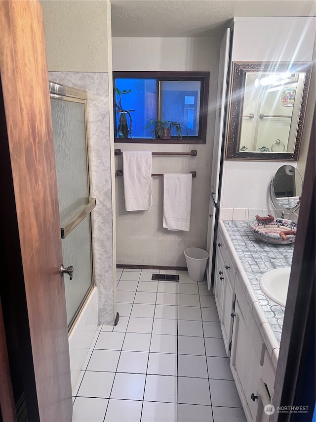 bathroom with a textured ceiling, tile flooring, and vanity