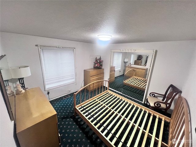 bedroom featuring a textured ceiling and carpet