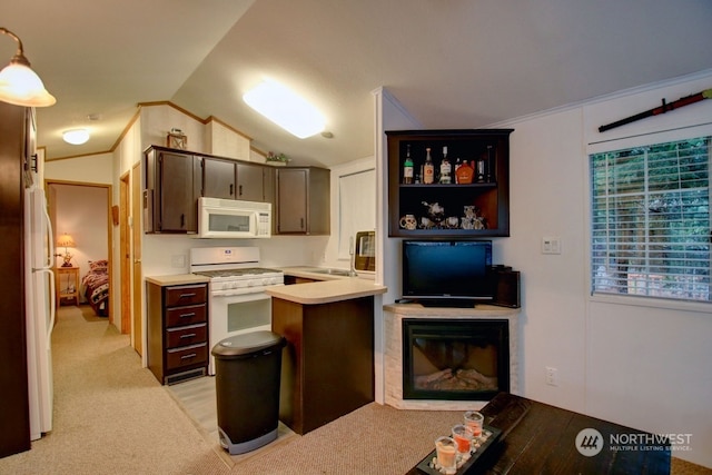 kitchen featuring white appliances, dark brown cabinets, decorative light fixtures, vaulted ceiling, and light colored carpet