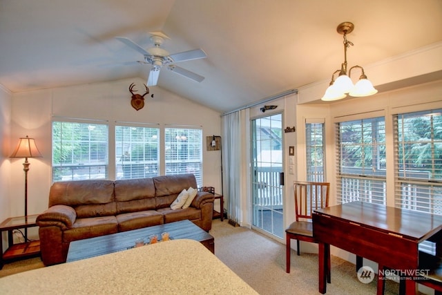 carpeted living room with ceiling fan with notable chandelier, vaulted ceiling, and ornamental molding