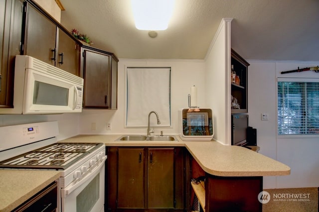 kitchen with a textured ceiling, white appliances, kitchen peninsula, sink, and dark brown cabinetry