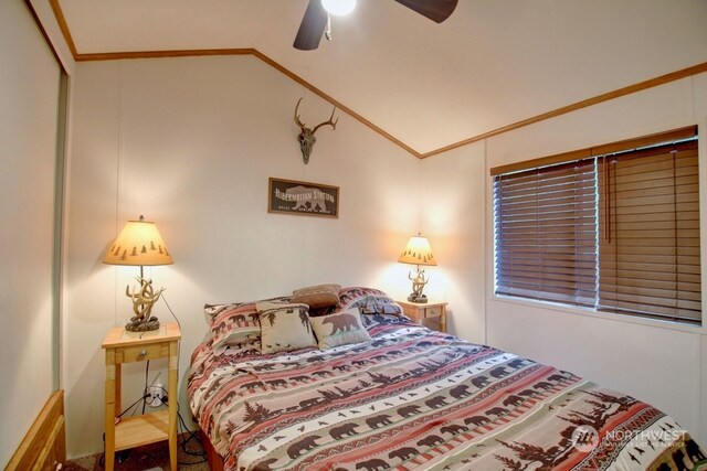 bedroom with crown molding, lofted ceiling, ceiling fan, and a closet