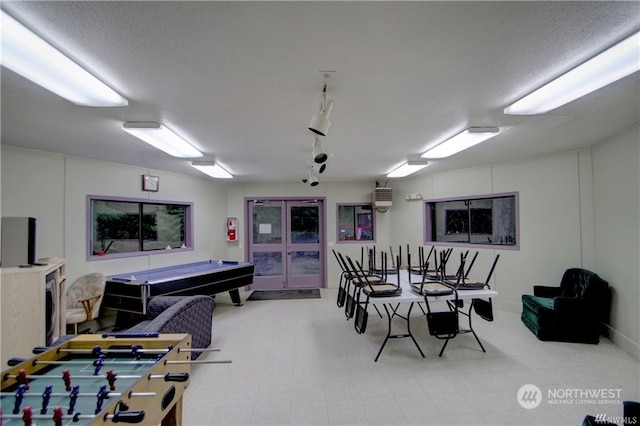 recreation room with a textured ceiling