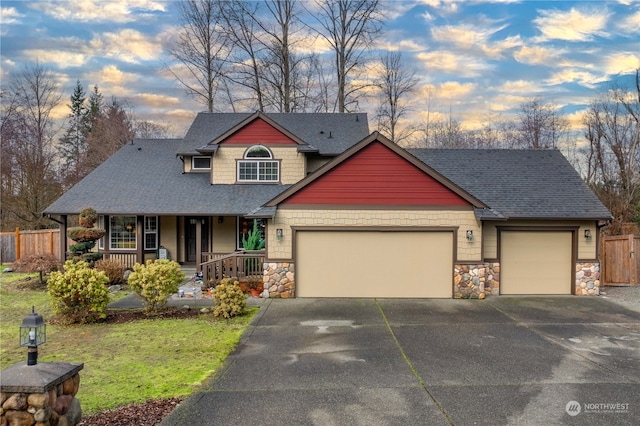 craftsman-style house featuring covered porch, a yard, and a garage