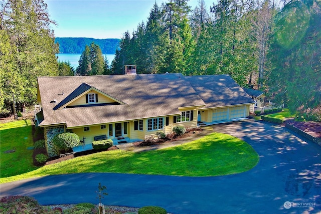 view of front of house featuring a front lawn, a mountain view, and a garage