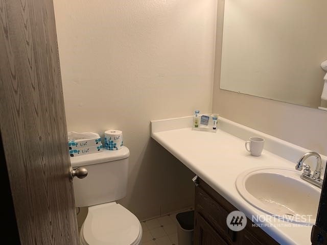 bathroom with vanity, toilet, and tile floors