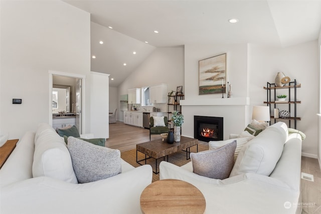 living room featuring light hardwood / wood-style floors and high vaulted ceiling