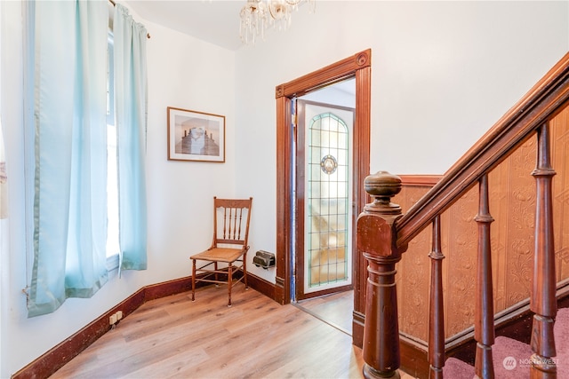 entryway with light hardwood / wood-style flooring and an inviting chandelier