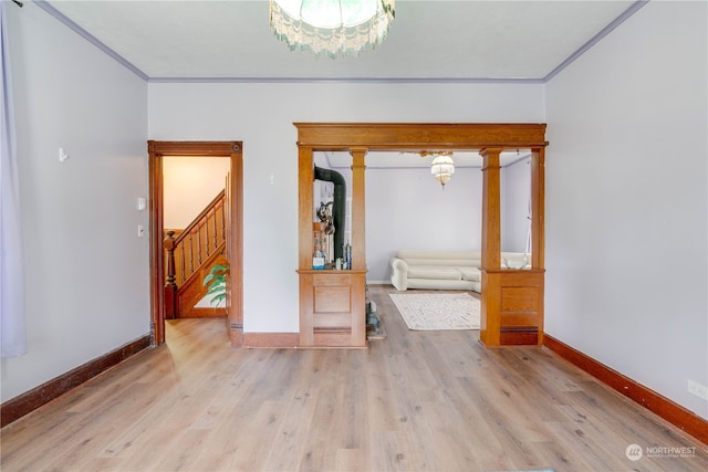 interior space with ornamental molding, a chandelier, and light hardwood / wood-style floors