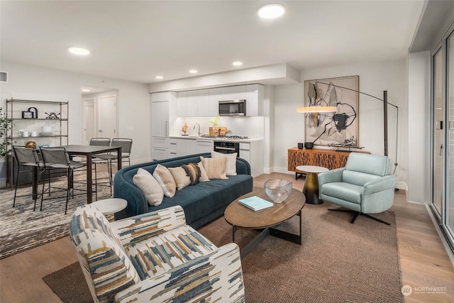 living room with light hardwood / wood-style flooring and sink