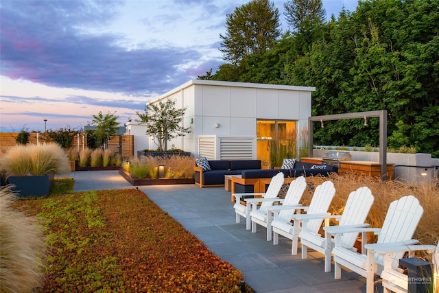 yard at dusk with an outdoor living space and a patio