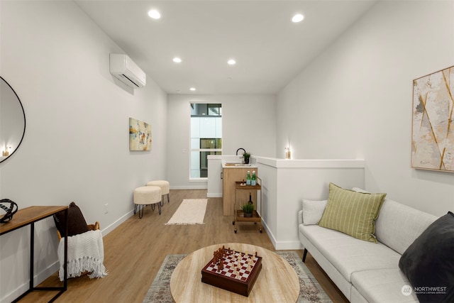 sitting room with a wall unit AC, sink, and light wood-type flooring