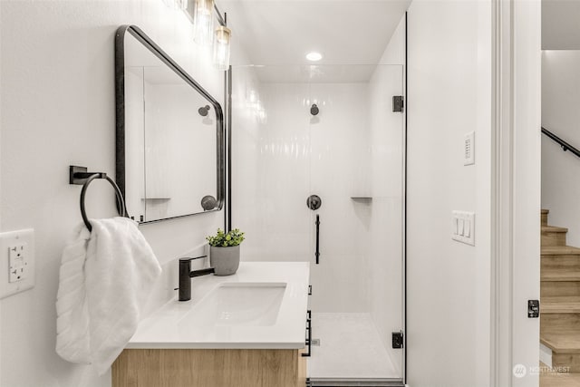 bathroom featuring vanity and a shower with door