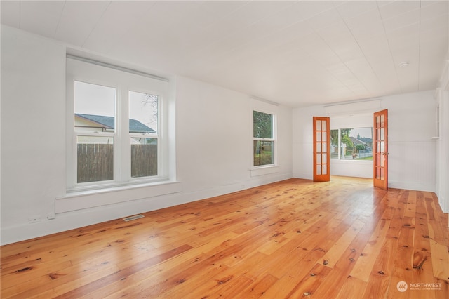 unfurnished room with french doors and light wood-type flooring