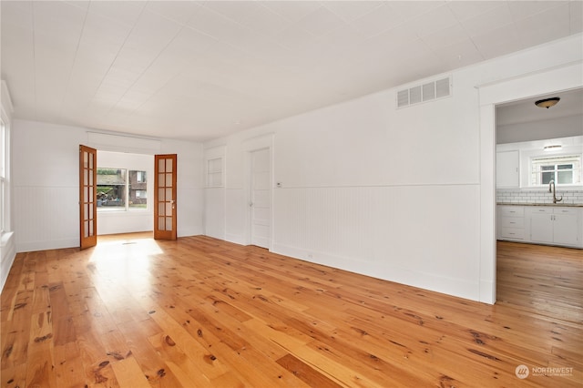 unfurnished room featuring light wood-type flooring and french doors