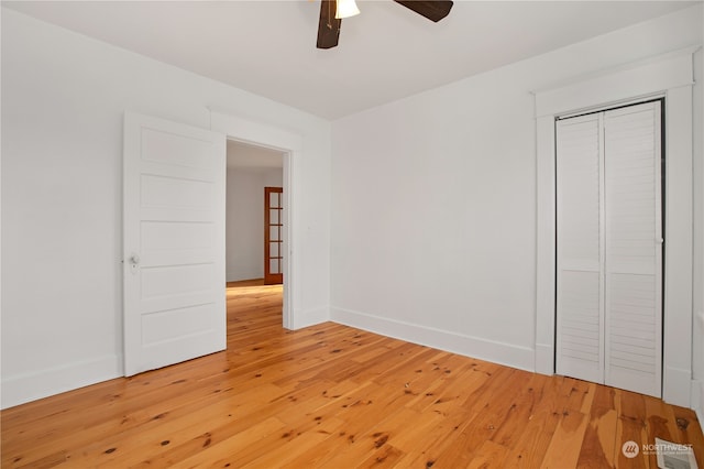 unfurnished bedroom featuring ceiling fan, a closet, and light hardwood / wood-style floors