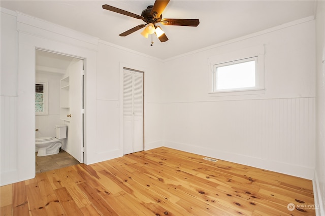 unfurnished bedroom featuring ensuite bathroom, ceiling fan, a closet, and light tile floors