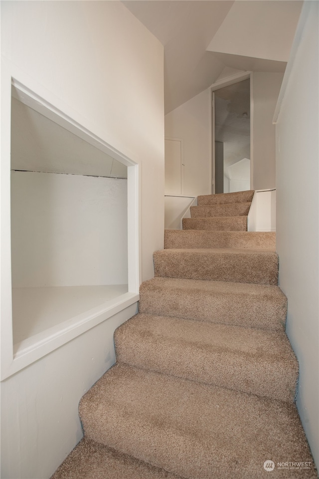 stairs featuring carpet and vaulted ceiling