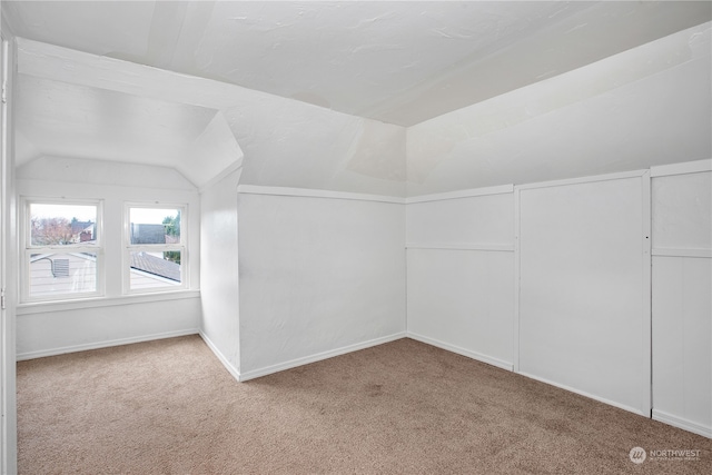 bonus room featuring lofted ceiling and light carpet