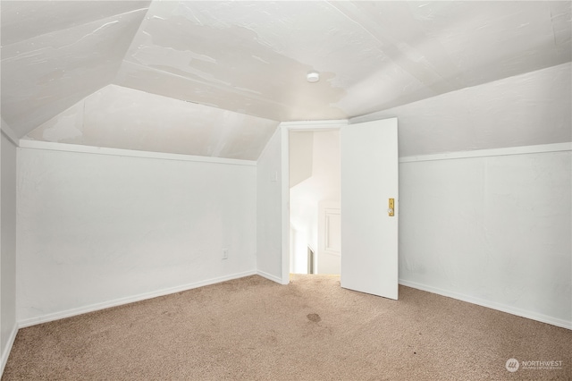 bonus room featuring light carpet and vaulted ceiling