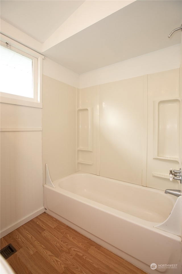 bathroom with shower / washtub combination and hardwood / wood-style flooring