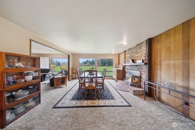 carpeted living room featuring a fireplace and brick wall