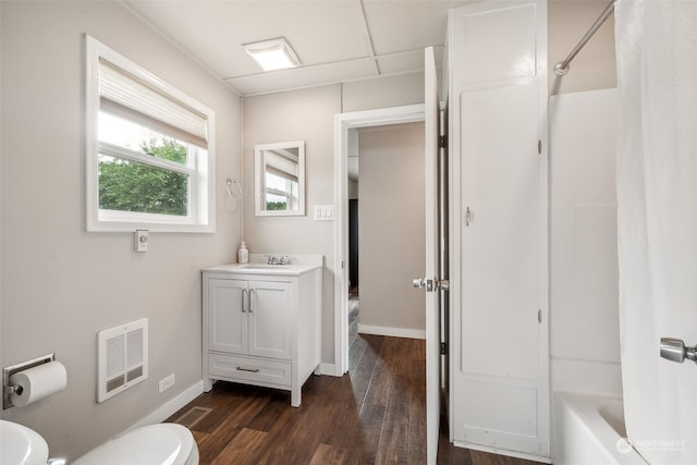 full bathroom featuring  shower combination, hardwood / wood-style floors, toilet, and vanity with extensive cabinet space