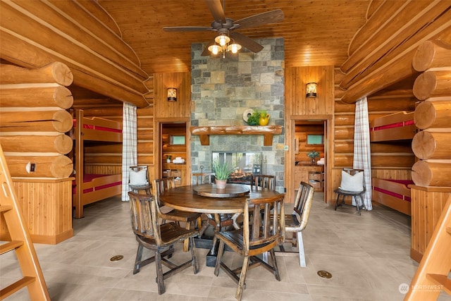 dining area with wooden ceiling, ceiling fan, and rustic walls