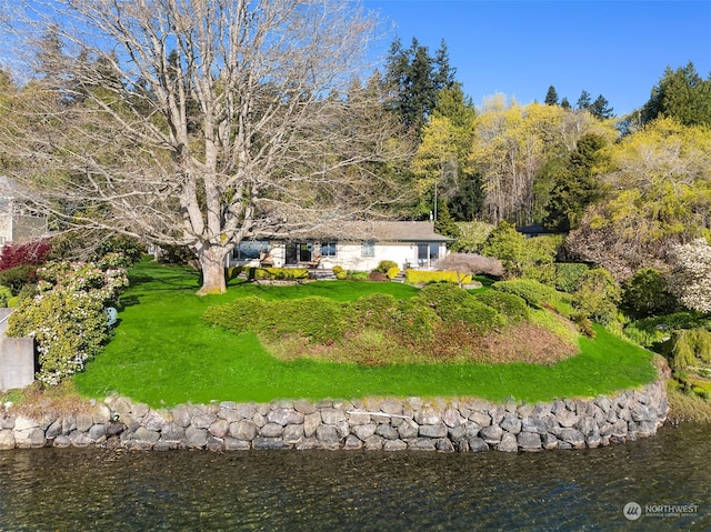 rear view of property with a yard and a water view