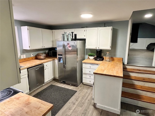 kitchen with wooden counters, stainless steel appliances, light wood-type flooring, and white cabinetry