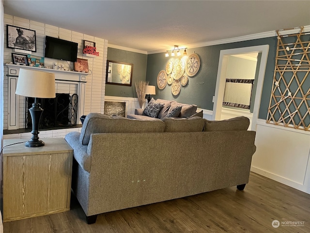 living room featuring crown molding, brick wall, a fireplace, and wood-type flooring