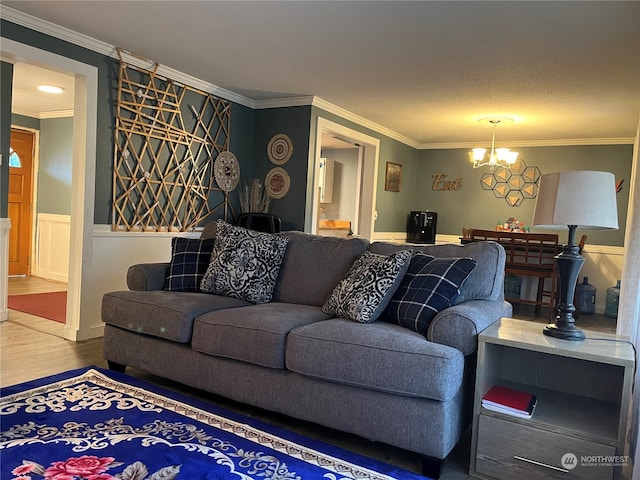 living room featuring a notable chandelier, a textured ceiling, crown molding, and hardwood / wood-style flooring