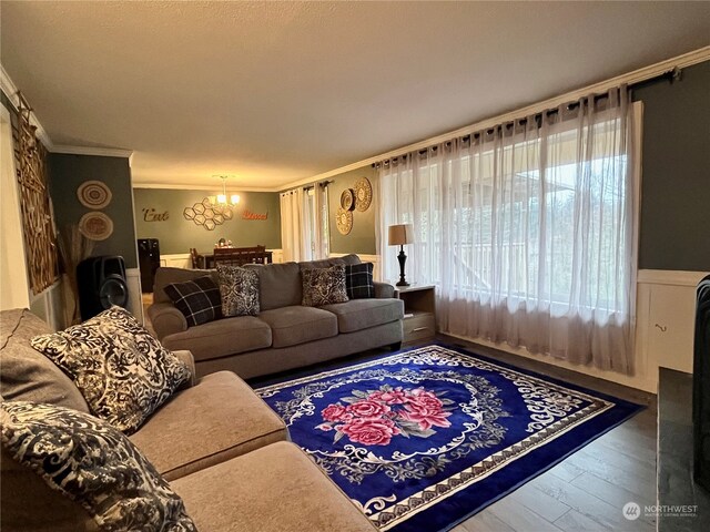 living room featuring a notable chandelier, crown molding, and dark hardwood / wood-style floors