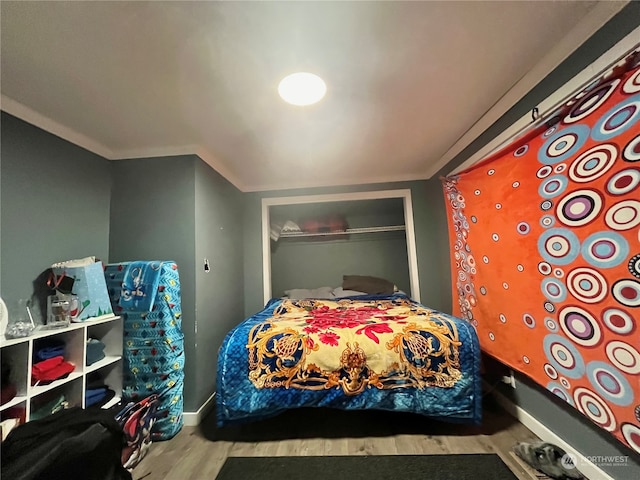 bedroom with ornamental molding, a closet, and light wood-type flooring