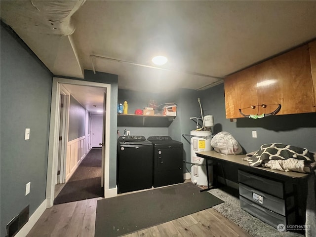 kitchen with strapped water heater, washing machine and dryer, and dark hardwood / wood-style floors