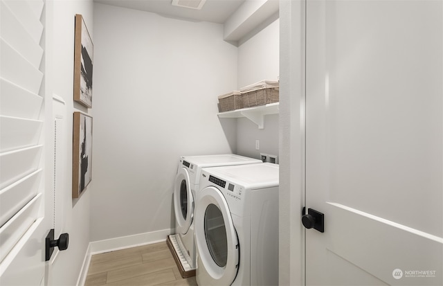 clothes washing area with washing machine and dryer